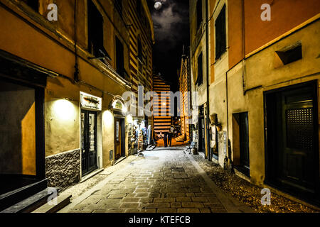 Un couple de baisser la tête d'une petite rue en direction de l'église de Saint Jean Baptiste sous une pleine lune à Monterosso al Mare, Cinque Terre Italie Banque D'Images