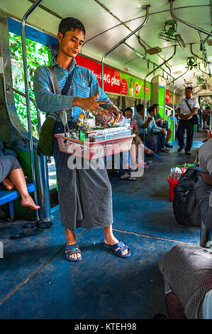 Yangon, Myanmar - Oct 22, 2017 : Un vendeur sur la ligne circulaire est la préparation d'arec avec pâte de chaux éteinte et l'enveloppa dans la feuille de bétel à un client Banque D'Images