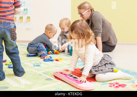 Les enfants jouent dans la salle de jeux. Fille joue avec piano toy Banque D'Images