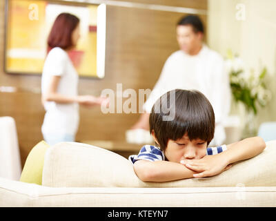 Enfant asiatique semble triste et malheureux alors que les parents se disputer à l'arrière-plan. Banque D'Images