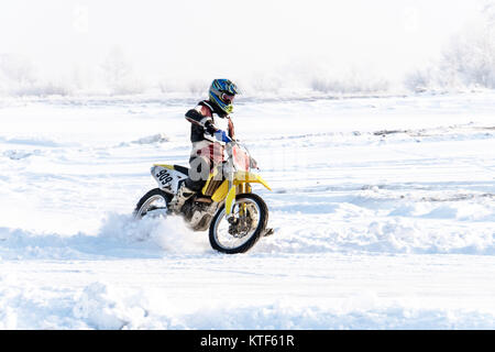 Racer sur une moto à tour de roues en un jet de la neige et de la boue pendant l'hiver la Coupe du motocross. Glisser sur une route enneigée. de la neige sous la roue Banque D'Images