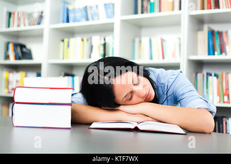 Fatigué student sleeping in library Banque D'Images