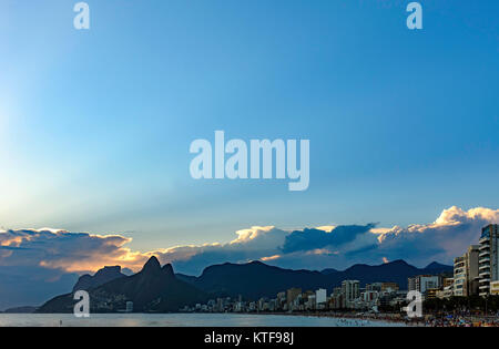 Coucher du soleil d'été avec ciel nuageux avec deux frères Hill et Vidigal slum vue depuis la plage d'Ipanema à Rio de Janeiro Banque D'Images