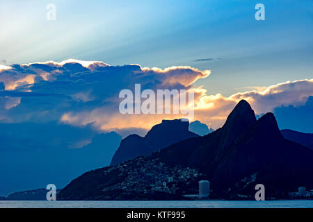 Coucher du soleil d'été avec ciel nuageux avec deux frères Hill et Vidigal slum vue depuis la plage d'Ipanema à Rio de Janeiro Banque D'Images