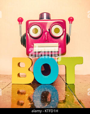 La tête du robot rouge et le mot BOT sur un sol en bois avec réflexion Banque D'Images