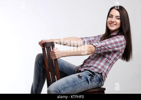 Assez heureux femme en chemise sur une chaise Banque D'Images