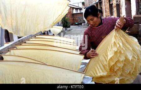 Taizhou, Zhejiang Province de la Chine. Le 24 décembre, 2017. Fang Yanfen sari caillé peau à Xiajie Village de Xianju Comté, Taizhou City, Zhejiang Province de Chine orientale, le 24 décembre 2017. Le caillé est une peau de Taizhou snack traditionnel. Credit : Wang Huabin/Xinhua/Alamy Live News Banque D'Images