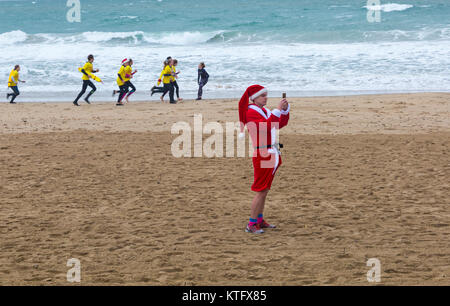 Boscombe, Bournemouth, Dorset, Royaume-Uni. Jour de Noël 25 décembre 2017. Des bénévoles courageux se plongent dans la mer froide et agitée pour nager, pour la 10e œuvre caritative annuelle White Christmas DIP, vêtue de costumes habillés de fantaisie et amassant de l'argent pour Macmillan Caring local à Christchurch, une unité de soins palliatifs spécialisée pour les patients de la communauté locale. Des centaines prennent part à l'événement qui est devenu une tradition populaire pour beaucoup avant leur déjeuner de Noël. Crédit : Carolyn Jenkins/Alay Live News Banque D'Images