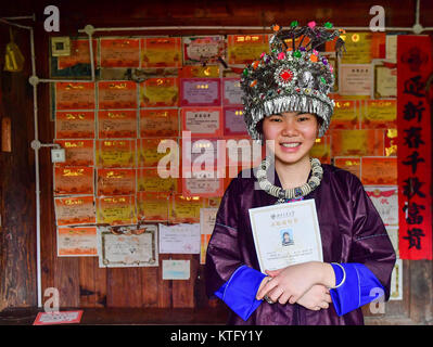 (171225) -- Paris, le 25 décembre, 2017 (Xinhua) -- Mo Youya, une fille de l'ethnie Dong, s'élève face à son prix des certificats dans Pingliu Dutong Ville située dans le village de Dong comté autonome de la Chine du sud, Sanjiang région autonome Zhuang du Guangxi, le 16 août 2017. Elle a été admise au sud-ouest de la Chine Jiaotong University en 2017. En raison de conditions environnementales sévères telles que la désertification et de relief montagneux, le Guangxi a longtemps été une région moins développée en Chine. Au cours des dernières années, le gouvernement local effectué de nombreuses mesures pour l'alléger la pauvreté. Des dizaines de flexibilite' Banque D'Images