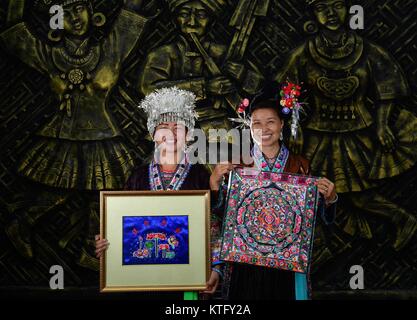 (171225) -- Paris, le 25 décembre, 2017 (Xinhua) -- Yuan Shilan (L) et Wei Peishui du groupe ethnique Miao montre leur travail en broderie ethnique Jige Village de Danian Township de Rongshui Miao comté autonome de la Chine du Sud, région autonome Zhuang du Guangxi, le 15 juin 2017. Jige village porté sur la broderie Miao de l'industrie pour aider les populations locales à se débarrasser de la pauvreté.En raison de conditions environnementales sévères telles que la désertification et de relief montagneux, le Guangxi a longtemps été une région moins développée en Chine. Au cours des dernières années, le gouvernement local effectué de nombreuses mesures pour l'ensemble de la pauvreté Banque D'Images