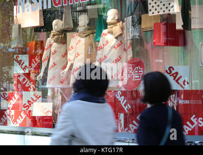 Tokyo, Japon. Déc 26, 2017. Les piétons passent avant qu'un aparel shop à Tokyo le Mardi, Décembre 26, 2017. Indice des prix à la consommation du Japon a augmenté de 0,9 pour cent en novembre, l'augmentation de 11e mois consécutif, le gouvernement a annoncé le 26 décembre. Credit : Yoshio Tsunoda/AFLO/Alamy Live News Banque D'Images