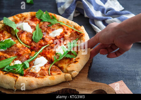 Les gens en tenant les mains des tranches de pizza Margherita. Fond noir. Banque D'Images