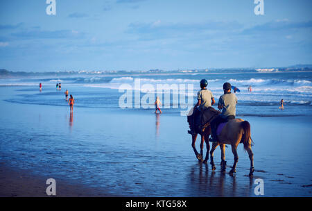 Les gens d'une circonscription chevaux sur la plage de Bali au coucher du soleil , Indonésie Banque D'Images