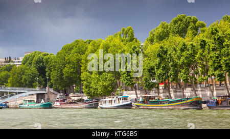 PARIS, FRANCE - Le 8 juin 2012 : bateaux amarrés le long de la Seine à Paris, avec les nuages de tempête dans l'arrière-plan. Banque D'Images