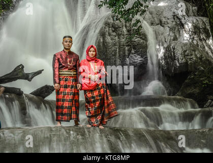 Un jeune couple pose en robe traditionnelle Bugis. Banque D'Images