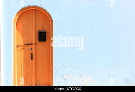 Porte en bois brun foncé sur fond bleu clair. Vue rapprochée, de l'espace pour le texte Banque D'Images