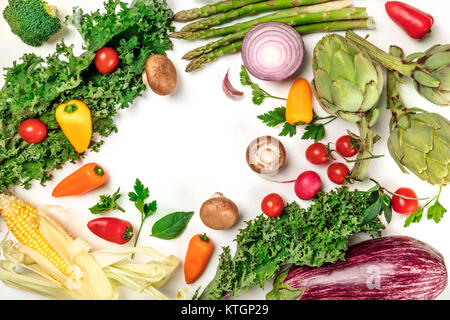 Une photo prise à la verticale de légumes frais et des champignons formant un cadre, tourné à partir de ci-dessus, sur un fond blanc avec une place pour le texte. Aliments biologiques sains Banque D'Images