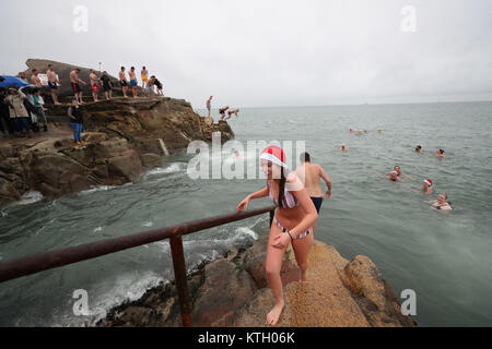 Les gens brave la pluie pour prendre part à la Journée annuelle de Noël nager dans les quarante pied, Dun Laoghaire. Banque D'Images