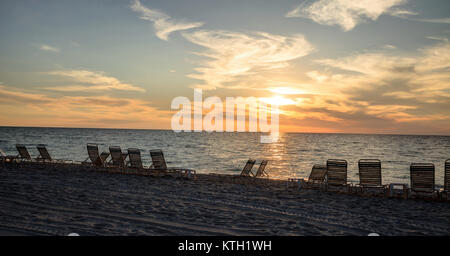 Chaises le long de la plage de Vanderbilt à Naples, Florida, USA au coucher du soleil Banque D'Images