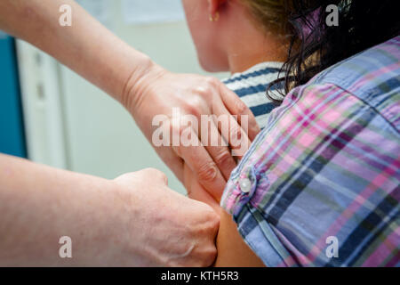 Main du médecin est de donner le vaccin par injection à l'enfant. Banque D'Images