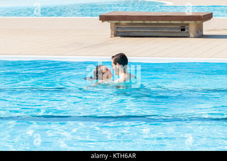 Jeune couple aimant baisers et se détend dans la piscine d'hydromassage Banque D'Images