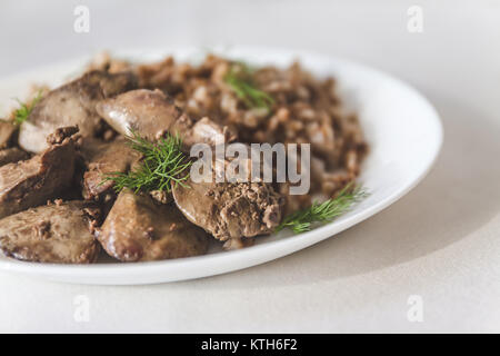 Foie de poulet compote et gruau de sarrasin sur une nappe blanche, en rétro tonifiant. Banque D'Images