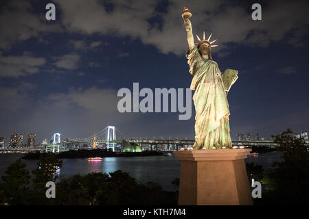 Le JAPON, Tokyo-CIRCA avr 2013 : Réplique de la Statue de la liberté est dans l'île d'Odaiba. Le pont en arc-en-ciel derrière elle la nuit. Odaiba est un grand artificial Banque D'Images