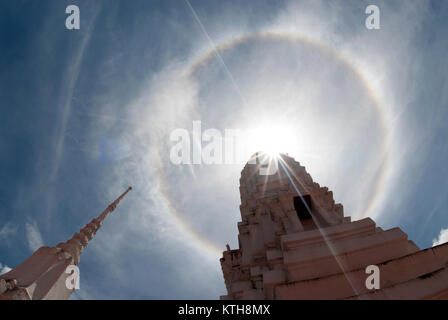 Halo solaire corona ou phénomène dans le ciel bleu et nuageux avec l'ancienne pagode thaïlandaise. Banque D'Images