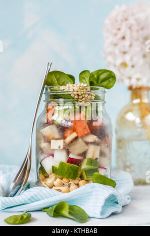 Tofu salade de pommes de terre douce chaude dans un pot, snack à emporter. Le tofu, les pois chiches et les pousses de sarrasin, patate douce, radis, épinards et le concombre. Santé Vegan Banque D'Images