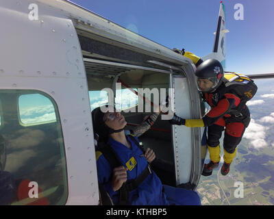 Cette équipe skydiving tandem est l'escalade hors de l'avion volant et s'apprête à plonger dans l'incertitude de la chute libre. Quelle est la prochaine étape ? Banque D'Images