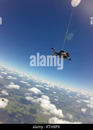 Cette équipe skydiving tandem jouit de la vol panoramique au-dessus d'un paysage magnifique. Haut dans le ciel bleu au-dessus des nuages. Banque D'Images