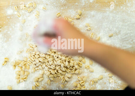 Décisions et l'élaboration de femme pisarei gnocchi pâtes typiques de l''Émilie-Romagne, Piacenza, Italie à la préparation de cuisine restaurant Banque D'Images