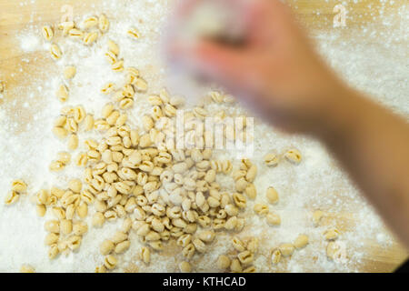 Décisions et l'élaboration de femme pisarei gnocchi pâtes typiques de l''Émilie-Romagne, Piacenza, Italie à la préparation de cuisine restaurant Banque D'Images