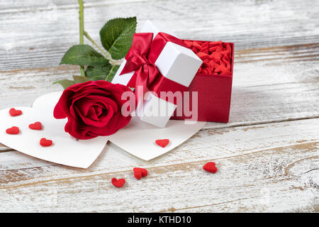 Ouvrir boîte cadeau Saint Valentin remplis de bonbons et rose rouge sur blanc rustique en bois vue en gros Banque D'Images