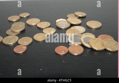 Certaines pièces en euros et quelques centimes sur un fond sombre donnant aux gens l'idée de l'économie d'argent dans de mauvaises situations économique.prendre soin d'un penny. Banque D'Images