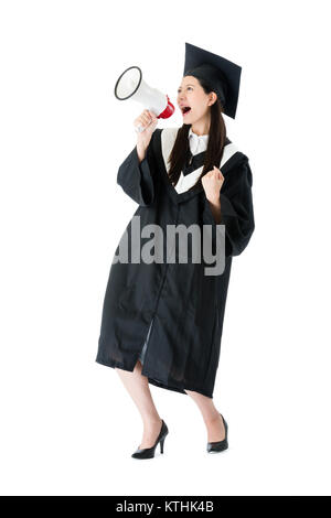 Cheerful young female college student using megaphone a annoncé qu'elle se diplôme et célébrer sur fond blanc. Banque D'Images