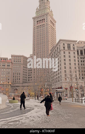 Juste après être sorti d'un bus public, les piétons brave les éléments de l'hiver alors qu'ils se précipitent à travers public Square dans le centre-ville de Cleveland, Ohio, États-Unis. Banque D'Images