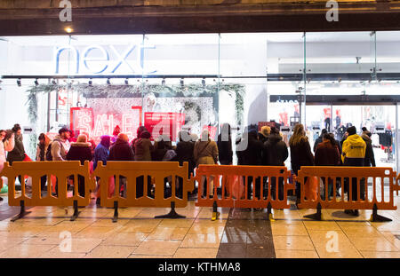 Les consommateurs à la prochaine vente Boxing Day à la prochaine boutique sur la rue Queen, à Cardiff, Pays de Galles. En file d'acheteurs de 1 h pour la vente avec le magasin ouvre ses portes aux clients à 6 heures ce matin. Banque D'Images