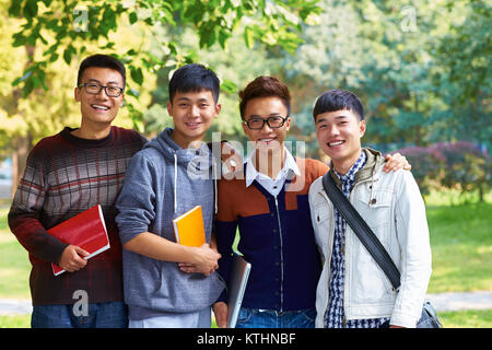 Groupe d'étudiants du collège asiatique à la caméra à sourire dans le campus Banque D'Images