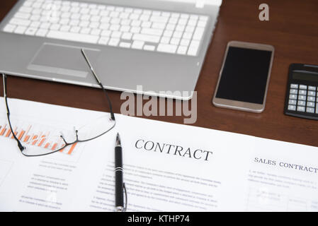 Concepts d'affaires avec contrat, portable, lunettes, calculatrices, et les graphiques sur le bureau Banque D'Images