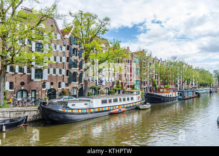 Amsterdam Pays-Bas - 13 août 2017 : beau canal à Amsterdam avec péniches et rangée de maisons d'architecture classique Banque D'Images