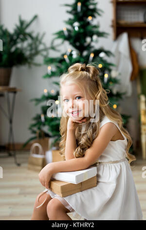 Little smiling girl with christmas gift box. Joyeux Noël et de bonnes vacances. Banque D'Images