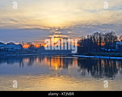 Cette image capture le lever de soleil à couper le souffle à Bydgoszcz, en Pologne, avec des couleurs éclatantes qui se répandent dans le ciel. La scène sereine met en valeur la beauté de la ville à l'aube. Banque D'Images