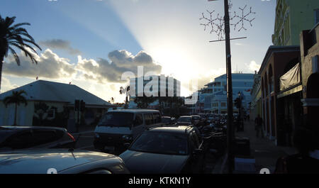 Une scène de rue à Hamilton, aux Bermudes, capturée près du coucher du soleil, mettant en valeur la beauté de l’architecture de l’île et l’ambiance tropicale. La photo met en valeur l'atmosphère sereine typique des rues des Bermudes au crépuscule. Banque D'Images