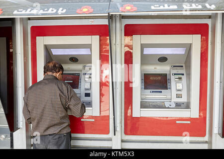 Yazd, Iran - avril 22, 2017 : Un vieil homme iranien utilise un guichet automatique pour retirer de l'argent à partir d'une carte de paiement nationale d'Iran. Banque D'Images