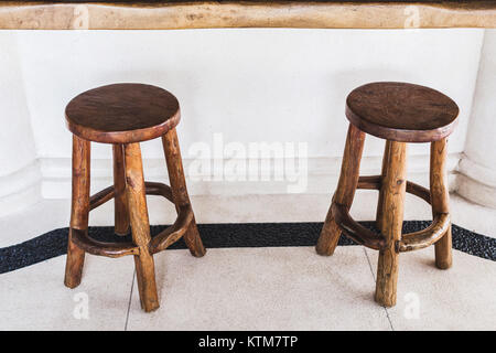 Vintage tabourets de bar en bois faits à la main sont alignés à la terrasse d'un café sur fond blanc Banque D'Images