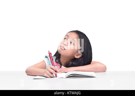 Portrait de petite fille asiatique avec stylo écrire sur l'ordinateur portable isolé sur fond blanc posant Banque D'Images