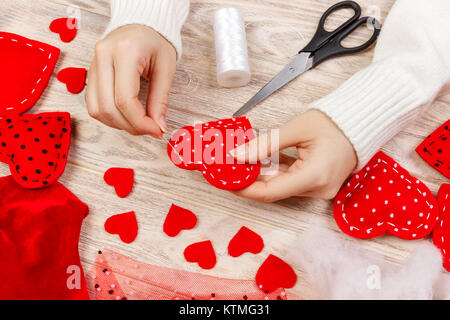 Femme création cœur rouge sur la table en bois. cadeau pour la Saint-Valentin faites à la main. Banque D'Images