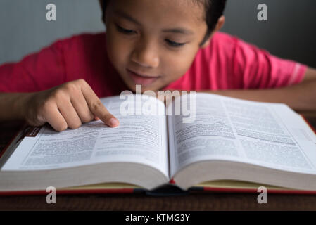 Jeune garçon asiatique de la lecture d'un livre concept éducatif. Banque D'Images