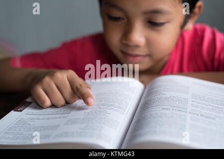 Jeune garçon asiatique de la lecture d'un livre concept éducatif. Banque D'Images